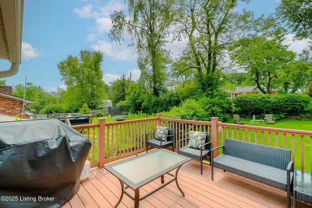 wooden terrace with grilling area, view of scattered trees, and a yard