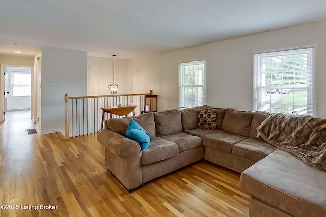 living room featuring light wood-style floors, healthy amount of natural light, and baseboards