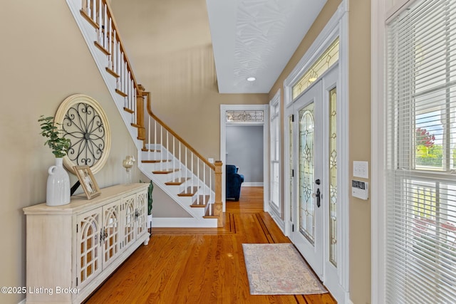 entrance foyer with stairway, wood finished floors, baseboards, recessed lighting, and french doors