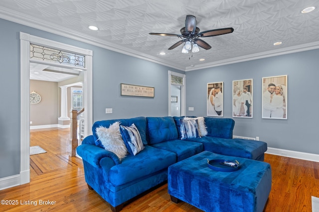 living room with a ceiling fan, baseboards, wood finished floors, recessed lighting, and ornamental molding