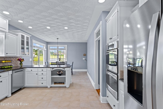kitchen featuring appliances with stainless steel finishes, a peninsula, white cabinetry, light tile patterned floors, and recessed lighting