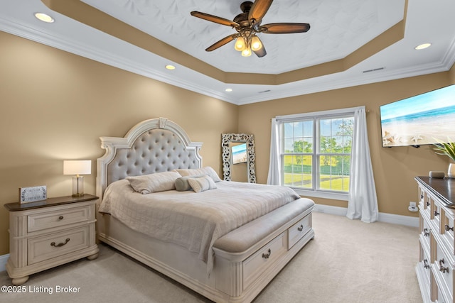 bedroom with light colored carpet, a raised ceiling, baseboards, recessed lighting, and crown molding