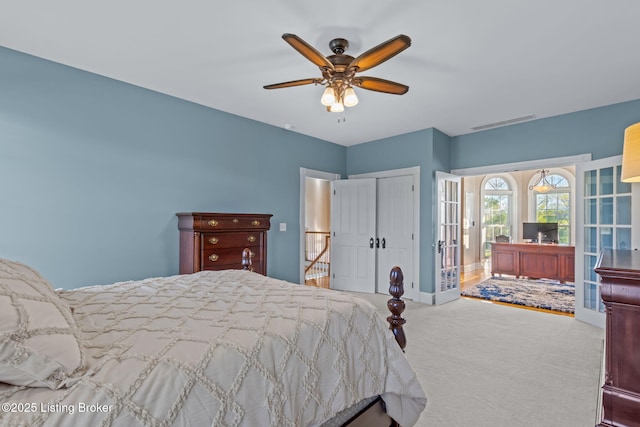 carpeted bedroom featuring a closet, a ceiling fan, and french doors