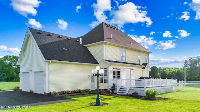 back of property featuring a wooden deck and a shingled roof