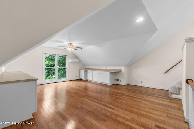 10304 Spring Meyer Rd, Louisville, KY 40223 - additional living space featuring an AC wall unit, light wood finished floors, a ceiling fan, lofted ceiling, and stairway