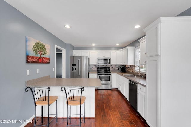 4313 Brownsboro Glen Rd, Louisville, KY 40241 - kitchen featuring appliances with stainless steel finishes, a sink, a peninsula, tasteful backsplash, and dark wood finished floors