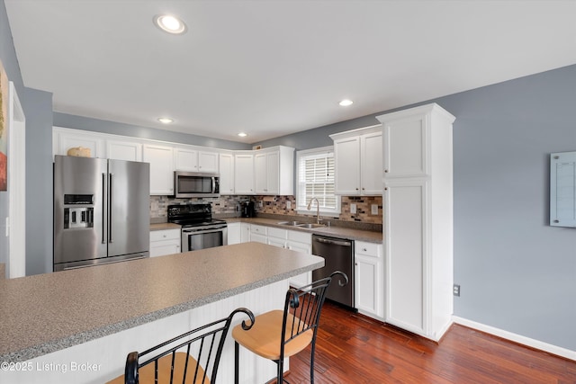4313 Brownsboro Glen Rd, Louisville, KY 40241 - kitchen with appliances with stainless steel finishes, dark wood-style floors, decorative backsplash, white cabinetry, and recessed lighting