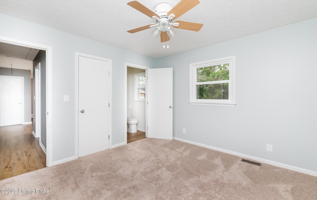 3009 Huberta Dr, Louisville, KY 40216 - unfurnished bedroom featuring attic access, baseboards, carpet floors, connected bathroom, and a textured ceiling