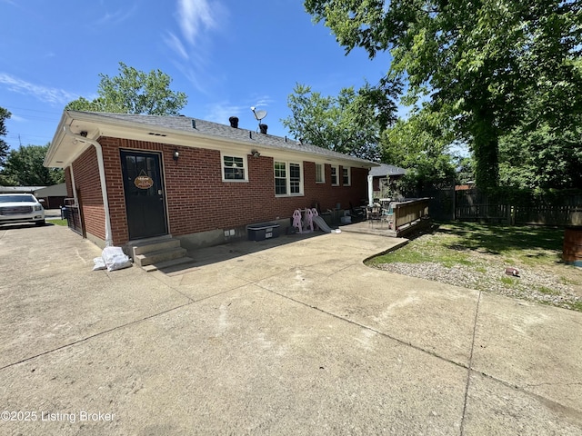 4919 Ferrer Way, Louisville, KY 40291 - rear view of property featuring entry steps, brick siding, fence, a patio area, and roof with shingles