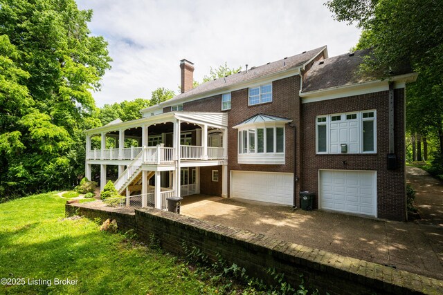 5302 Olde Creek Way, Prospect, KY 40059 - back of property featuring a chimney, stairway, brick siding, driveway, and an attached garage