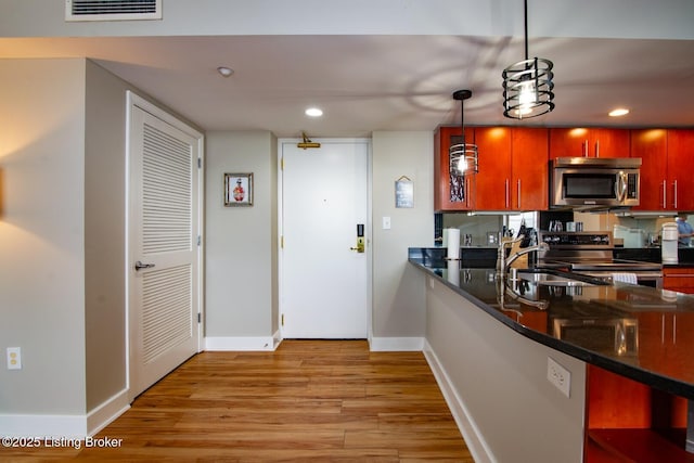 604 S 3rd St Unit 803, Louisville, KY 40202 - kitchen with stainless steel appliances, dark countertops, light wood-style floors, baseboards, and recessed lighting