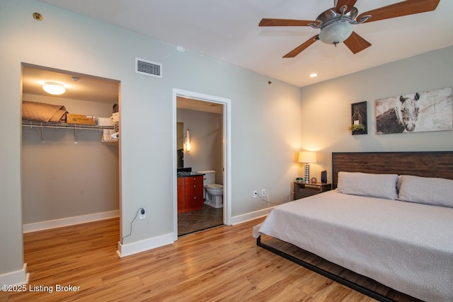 604 S 3rd St Unit 803, Louisville, KY 40202 - bedroom with light wood-style floors, a closet, baseboards, a walk in closet, and ensuite bathroom