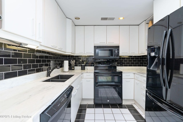 711 W Main St Unit T, Louisville, KY 40202 - kitchen with black appliances, tile patterned flooring, a sink, white cabinetry, and tasteful backsplash