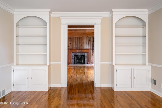 3920 Elfin Ave, Louisville, KY 40207 - unfurnished living room with wood finished floors, built in shelves, baseboards, a brick fireplace, and ornamental molding