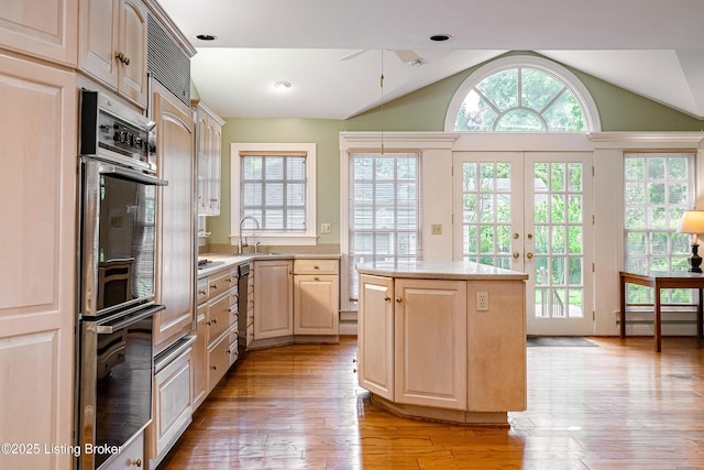 3920 Elfin Ave, Louisville, KY 40207 - kitchen featuring light countertops, lofted ceiling, light brown cabinets, healthy amount of natural light, and light wood-style floors