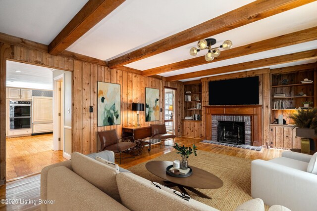 3920 Elfin Ave, Louisville, KY 40207 - living room featuring wooden walls, light wood-style floors, a fireplace, and beam ceiling