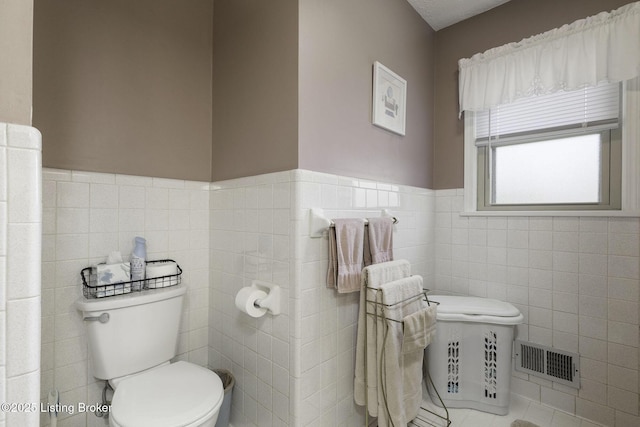 7407 Beahl Blvd, Louisville, KY 40258 - bathroom with tile walls, toilet, wainscoting, and tile patterned floors