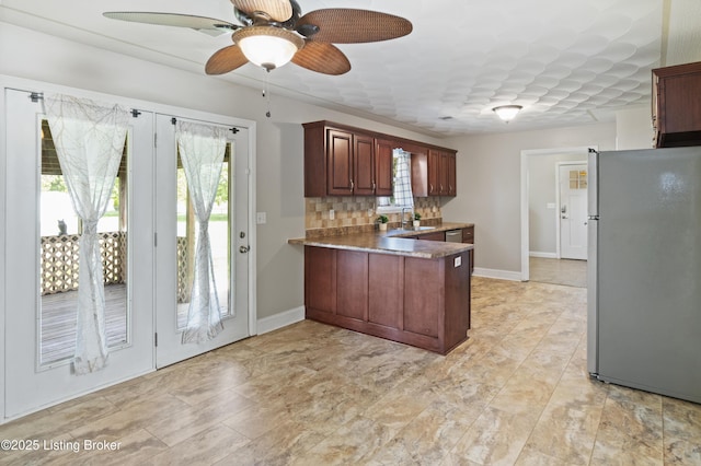 1020 Polley Dr, Bardstown, KY 40004 - kitchen featuring freestanding refrigerator, a peninsula, ceiling fan, a sink, and tasteful backsplash