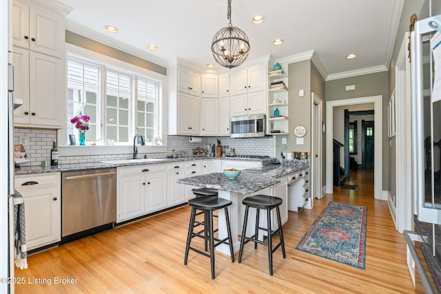 2220 Alta Ave, Louisville, KY 40205 - kitchen featuring stainless steel appliances, a sink, white cabinets, a chandelier, and crown molding