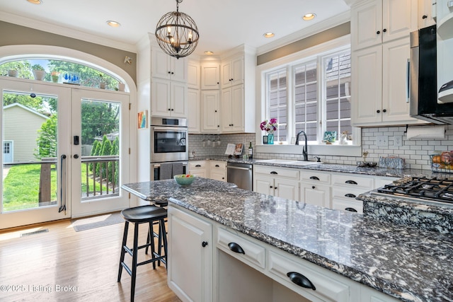 2220 Alta Ave, Louisville, KY 40205 - kitchen featuring a sink, stainless steel appliances, ornamental molding, white cabinetry, and dark stone countertops