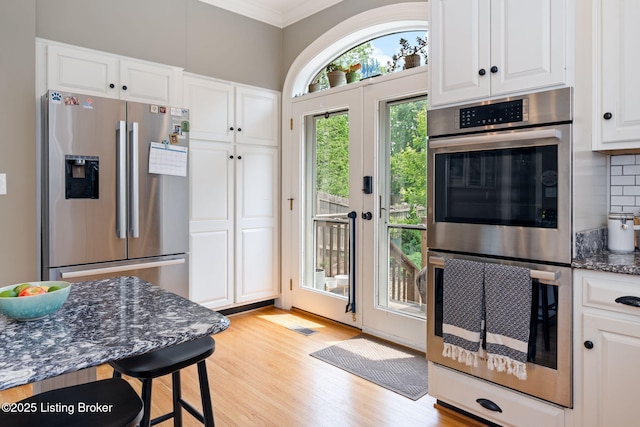 2220 Alta Ave, Louisville, KY 40205 - kitchen featuring appliances with stainless steel finishes, white cabinets, backsplash, ornamental molding, and dark stone countertops