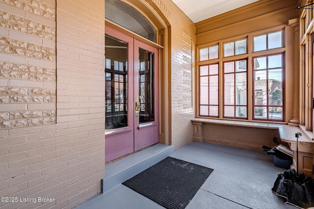 211 Haldeman Ave, Louisville, KY 40206 - doorway to property with french doors, covered porch, and brick siding