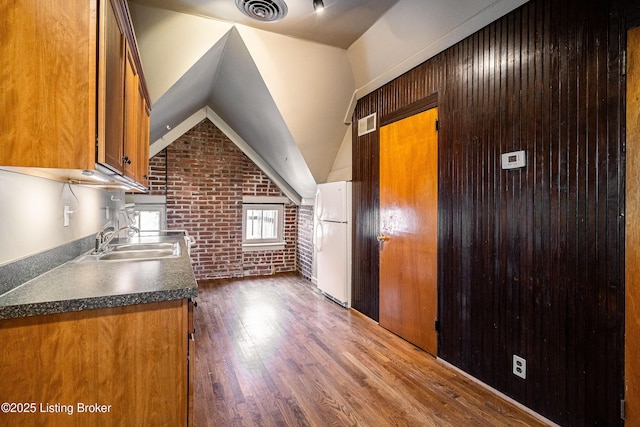 211 Haldeman Ave, Louisville, KY 40206 - kitchen featuring brick wall, a sink, freestanding refrigerator, brown cabinets, and dark wood-type flooring
