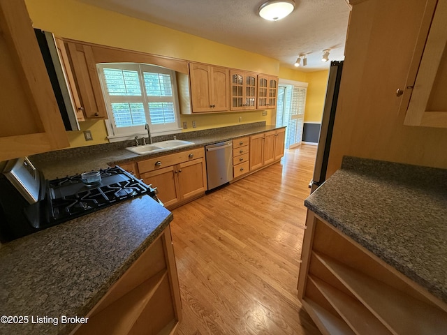 7406 Arapaho Dr, Louisville, KY 40214 - kitchen featuring stainless steel dishwasher, a sink, dark countertops, light wood-style floors, and a textured ceiling