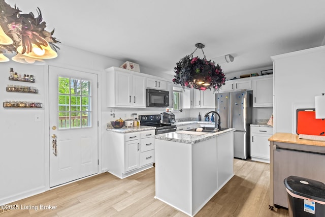 7333 W Orchard Grass Blvd, Crestwood, KY 40014 - kitchen featuring black microwave, range with electric stovetop, light wood-style flooring, white cabinetry, and an island with sink