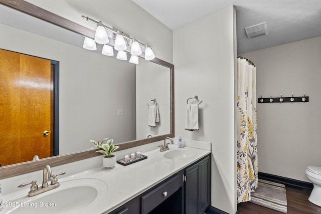 4308 Fence Pl, Louisville, KY 40241 - full bath featuring toilet, wood finished floors, double vanity, a shower with shower curtain, and baseboards