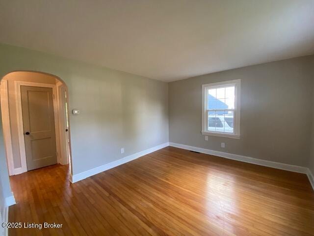 820 Johnson St, Bardstown, KY 40004 - spare room featuring arched walkways, wood finished floors, and baseboards