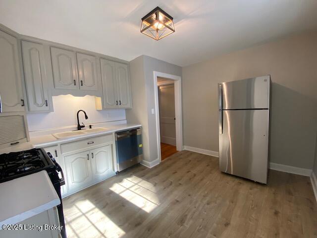 820 Johnson St, Bardstown, KY 40004 - kitchen featuring stainless steel appliances, a sink, light wood-type flooring, light countertops, and baseboards