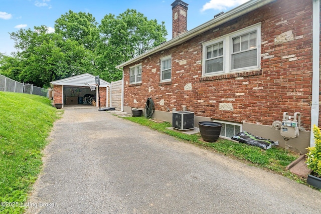1883 Allgeier Ct, Louisville, KY 40213 - view of home's exterior featuring central AC, brick siding, an outdoor structure, and a chimney