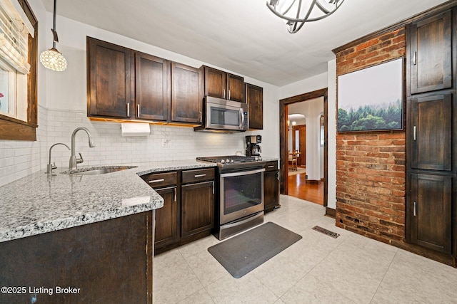 1883 Allgeier Ct, Louisville, KY 40213 - kitchen featuring stainless steel appliances, a sink, dark brown cabinetry, and light stone countertops