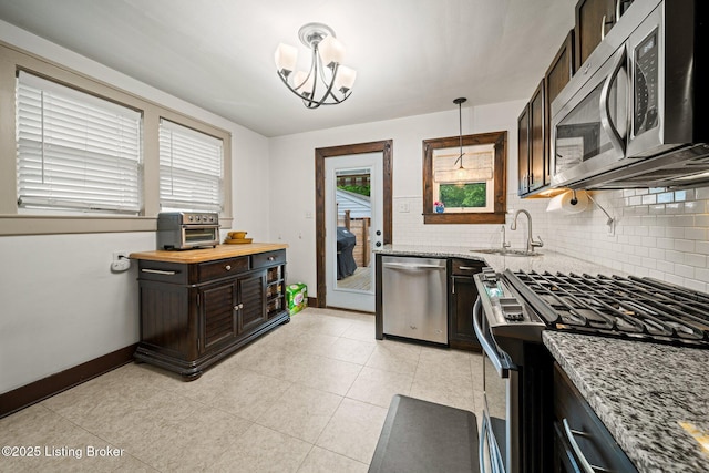 1883 Allgeier Ct, Louisville, KY 40213 - kitchen with stainless steel appliances, a sink, baseboards, light stone counters, and decorative backsplash