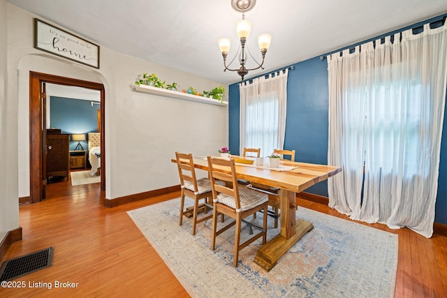 1883 Allgeier Ct, Louisville, KY 40213 - dining space featuring wood finished floors, a chandelier, arched walkways, and baseboards