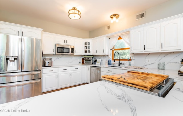 151 Pleasant Railway, Taylorsville, KY 40071 - kitchen featuring appliances with stainless steel finishes, white cabinetry, decorative backsplash, and light stone countertops