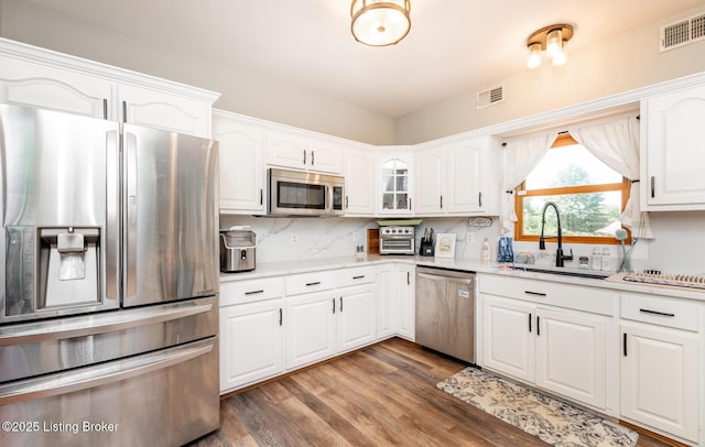 151 Pleasant Railway, Taylorsville, KY 40071 - kitchen with stainless steel appliances, wood finished floors, white cabinets, a sink, and decorative backsplash