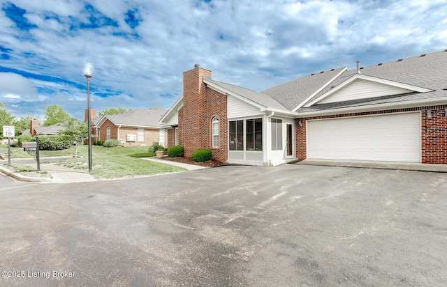 11330 Ridge Lake Dr, Louisville, KY 40272 - single story home with brick siding, a chimney, an attached garage, and asphalt driveway