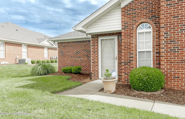 11330 Ridge Lake Dr, Louisville, KY 40272 - view of exterior entry featuring brick siding, a yard, and central AC