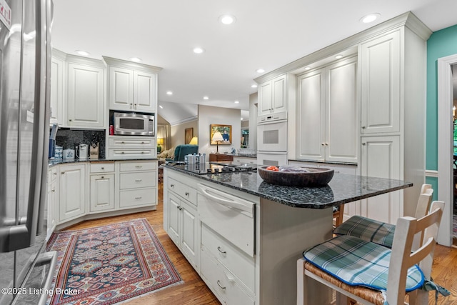 12104 Locust Ln, Anchorage, KY 40223 - kitchen with a warming drawer, stainless steel appliances, a kitchen breakfast bar, light wood finished floors, and recessed lighting
