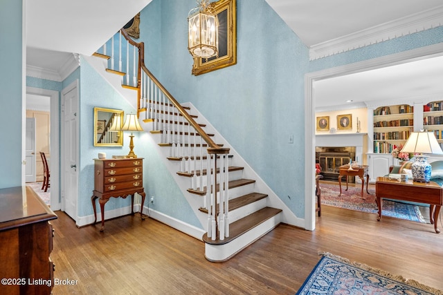 12104 Locust Ln, Anchorage, KY 40223 - stairs with wood finished floors, crown molding, a glass covered fireplace, a chandelier, and baseboards