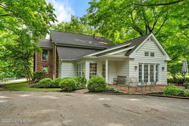 12104 Locust Ln, Anchorage, KY 40223 - view of front of house featuring roof with shingles, a patio area, and brick siding