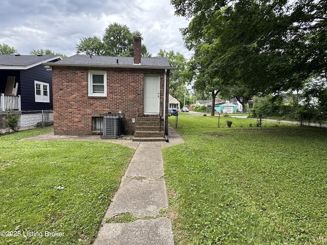4229 Grand Ave, Louisville, KY 40211 - back of house with a chimney, cooling unit, brick siding, entry steps, and a shingled roof