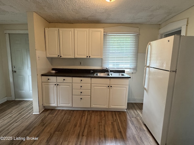 4229 Grand Ave, Louisville, KY 40211 - kitchen with freestanding refrigerator, a sink, white cabinets, dark wood-style flooring, and a textured ceiling