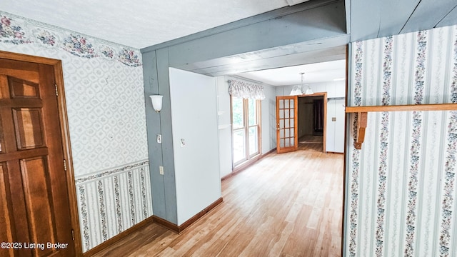 1250 Arnold School Rd, Webster, KY 40176 - corridor featuring wallpapered walls, light wood-style floors, baseboards, and a chandelier
