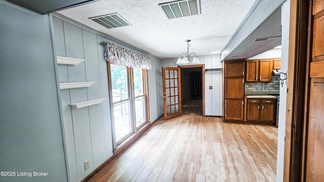 1250 Arnold School Rd, Webster, KY 40176 - unfurnished dining area featuring light wood-style floors, a chandelier, a textured ceiling, and baseboards