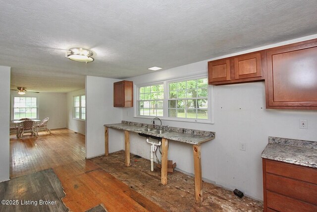 485 Hazzard St, Scottsburg, IN 47170 - kitchen with a sink, wood-type flooring, brown cabinetry, and a textured ceiling