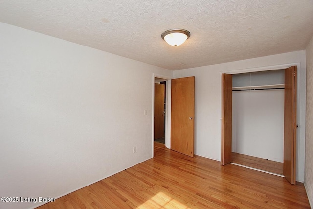 485 Hazzard St, Scottsburg, IN 47170 - unfurnished bedroom featuring light wood finished floors, a closet, and a textured ceiling