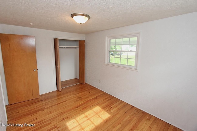 485 Hazzard St, Scottsburg, IN 47170 - unfurnished bedroom featuring a closet, light wood-type flooring, and a textured ceiling